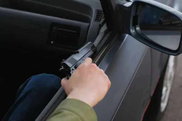 Displaying gun from car.