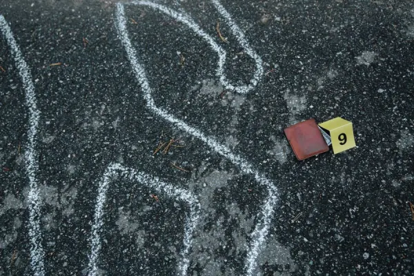 Homicide scene with a body outline and evidence.